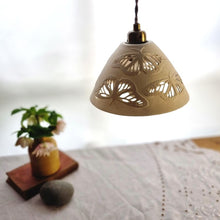 Load image into Gallery viewer, Porcelain Lampshade etched with Monarch butterflies. A vase with flowers, a book and a pebble in the background.
