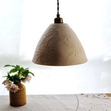 Load image into Gallery viewer, Cream unlit Porcelain Lampshade etched with swirling Jasmine design. Yellow vase with flowers in the background.