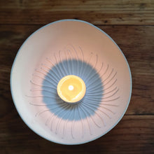 Load image into Gallery viewer, Handmade porcelain tealight holder inspired by the Cornish coast, glowing warmly as it holds a tealight, with soft light enhancing its coastal charm.