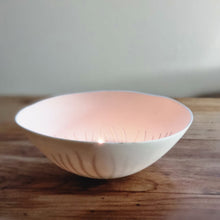 Load image into Gallery viewer, Porcelain tealight holder crafted by hand, inspired by Cornwall’s coastline, warmly glowing with a lit tealight inside.