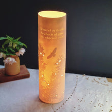 Load image into Gallery viewer, Porcelain cylinder Lamp etched with Gorse design in silhouette and words from the James Goodman poem Clay country. glowing warmly.
