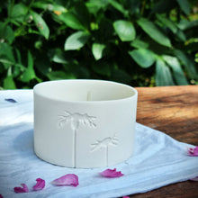 Load image into Gallery viewer, Translucent Porcelain pot with two daisies etched into it. with foliage in the background.