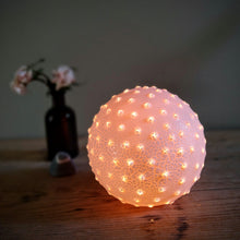 Load image into Gallery viewer, Sparkly Porcelain sphere glowing orange. Textured surface with bright dots.