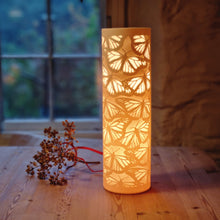 Load image into Gallery viewer, Monarch Butterfly Cylinder Lamp, glowing rich orange, brightest at the top.