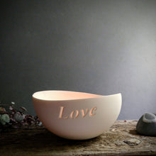 Load image into Gallery viewer, Tealight bowl inscribed with the word Love. on rustic wood with a grey wall behind.