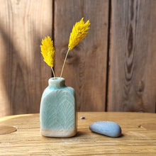 Load image into Gallery viewer, Small textured stoneware vase with turquoise glaze on a wooden surface.
