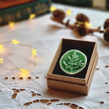 Load image into Gallery viewer, Rich shiny green porcelain brooch in brown gift box.
