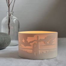 Load image into Gallery viewer, Porcelain Tealight Holder etched with Carn Galver mine design, glowing gently.
