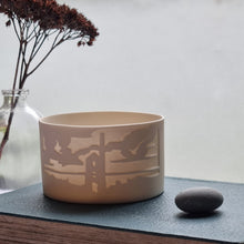 Load image into Gallery viewer, Porcelain Tealight Holder etched with Carn Galver mine design, glowing gently.

