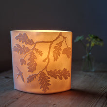 Load image into Gallery viewer, Oak tree-inspired porcelain ellipse lamp, featuring intricate etchings of oak leaves and branches, radiating a warm, nature-infused glow.
