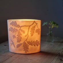 Load image into Gallery viewer, Oak tree-inspired porcelain ellipse lamp, featuring intricate etchings of oak leaves and branches, radiating a warm, nature-infused glow.
