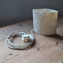 Load image into Gallery viewer, Oak tree-inspired porcelain ellipse lamp, displayed on a wooden table. The lamp features a braided cord with plug and switch. 
