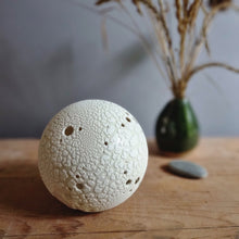 Load image into Gallery viewer, An unlit lamp, a white spherical porcelain object with textured surface and round holes.
