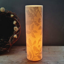 Load image into Gallery viewer, Porcelain Lamp etched with Oak leaf design and some swallows. Glowing orange.
