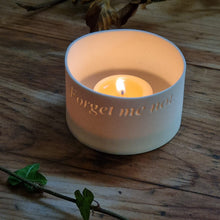 Load image into Gallery viewer, Porcelain Tealight pot etched with the words &#39;Forget me not...&#39;, gently glowing.
