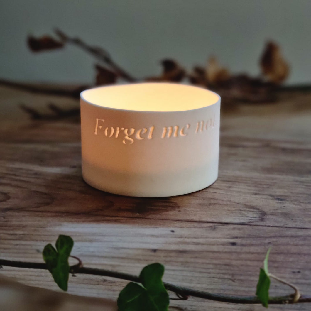 Porcelain Tealight pot etched with the words 'Forget me not...', gently glowing.