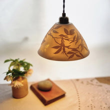 Load image into Gallery viewer, Porcelain Lampshade etched with wild roses and a butterfly. A vase with flowers, a book and a pebble in the background.
