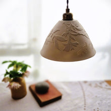 Load image into Gallery viewer, Creamy white porcelain Lampshade etched with wild roses and a butterfly. A vase with flowers, a book and a pebble in the background.

