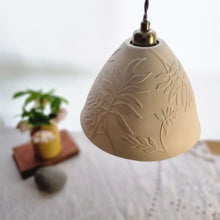 Load image into Gallery viewer, Porcelain Lampshade, etched with swirling Ash leaf design. Yellow vase with flowers in the background.
