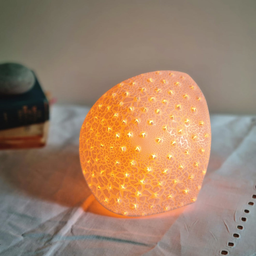 Diamond shaped orange glowing spotted porcelain lamp.
