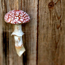 Load image into Gallery viewer, Decorative mushroom ornament hanging on a wooden surface
