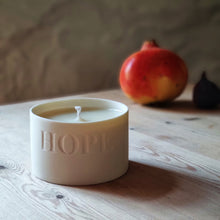 Load image into Gallery viewer, Porcelain Candle Pot etched with the word &#39;HOPE&#39;, pomegranite in the background.
