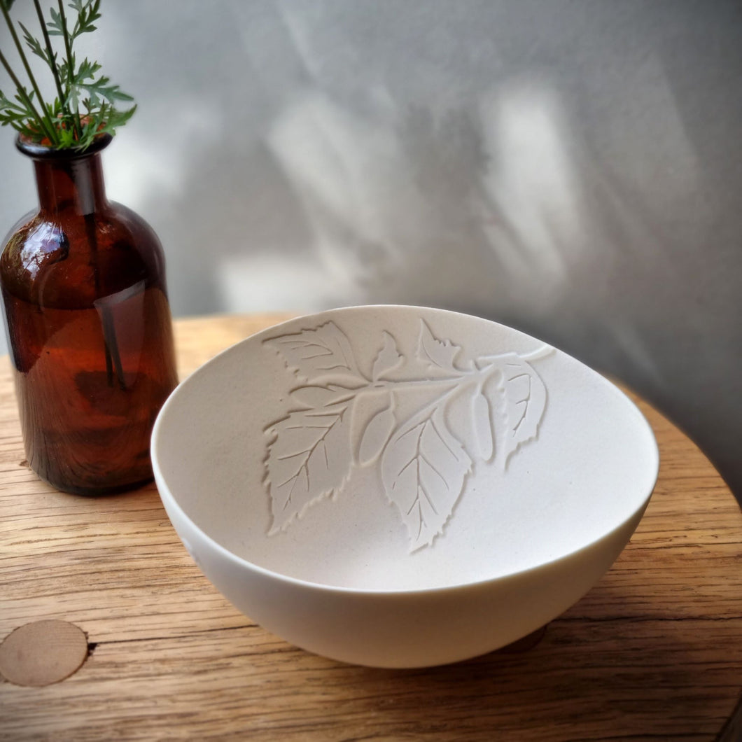 Translucent porcelain bowl with a Birch leaf design etched onto the inside.