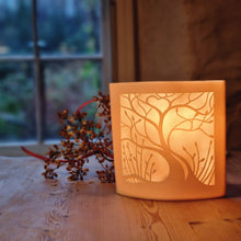 Load image into Gallery viewer, Lovers Tree square elliptical lamp, tree depicted in silouette with heart in the branches. The piece is glowing orange.
